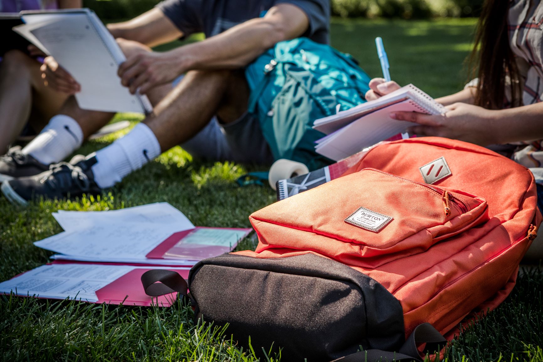 people studying outside with backpacks