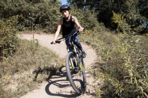 girl riding mountain bike on dirt path