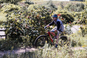 man riding red mountain bike over dirt path